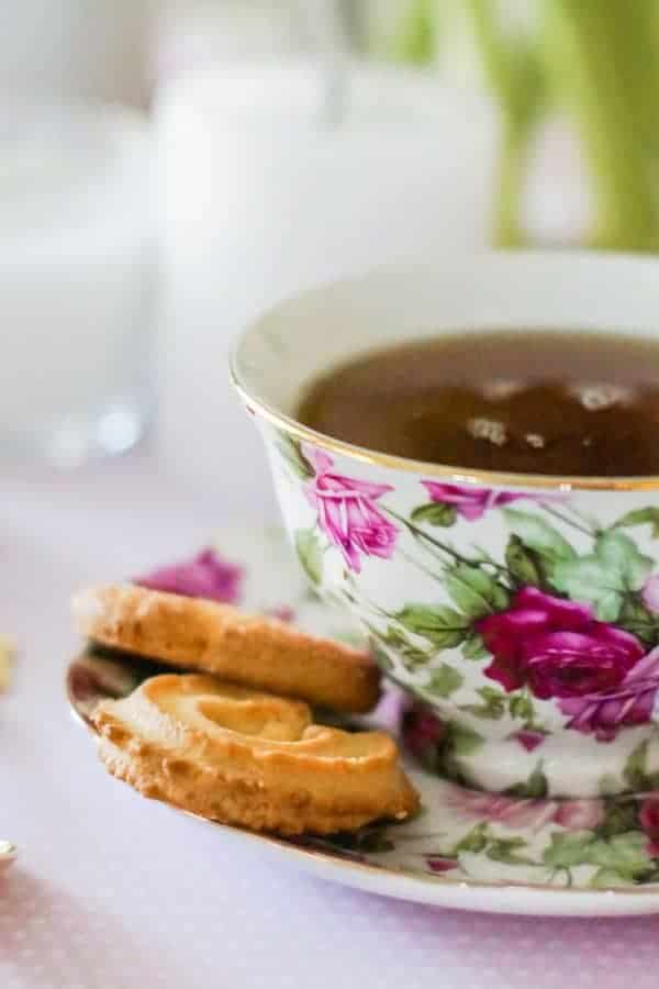 a cup of best earl grey tea with biscuit on the saucer