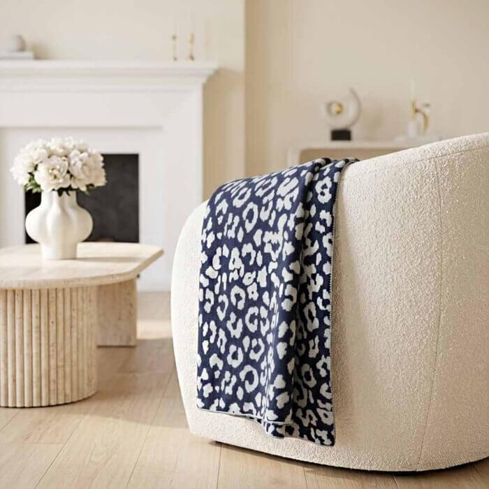 Cotton knit leopard throw blanket folded showing reversible navy and cream pattern handmade in India