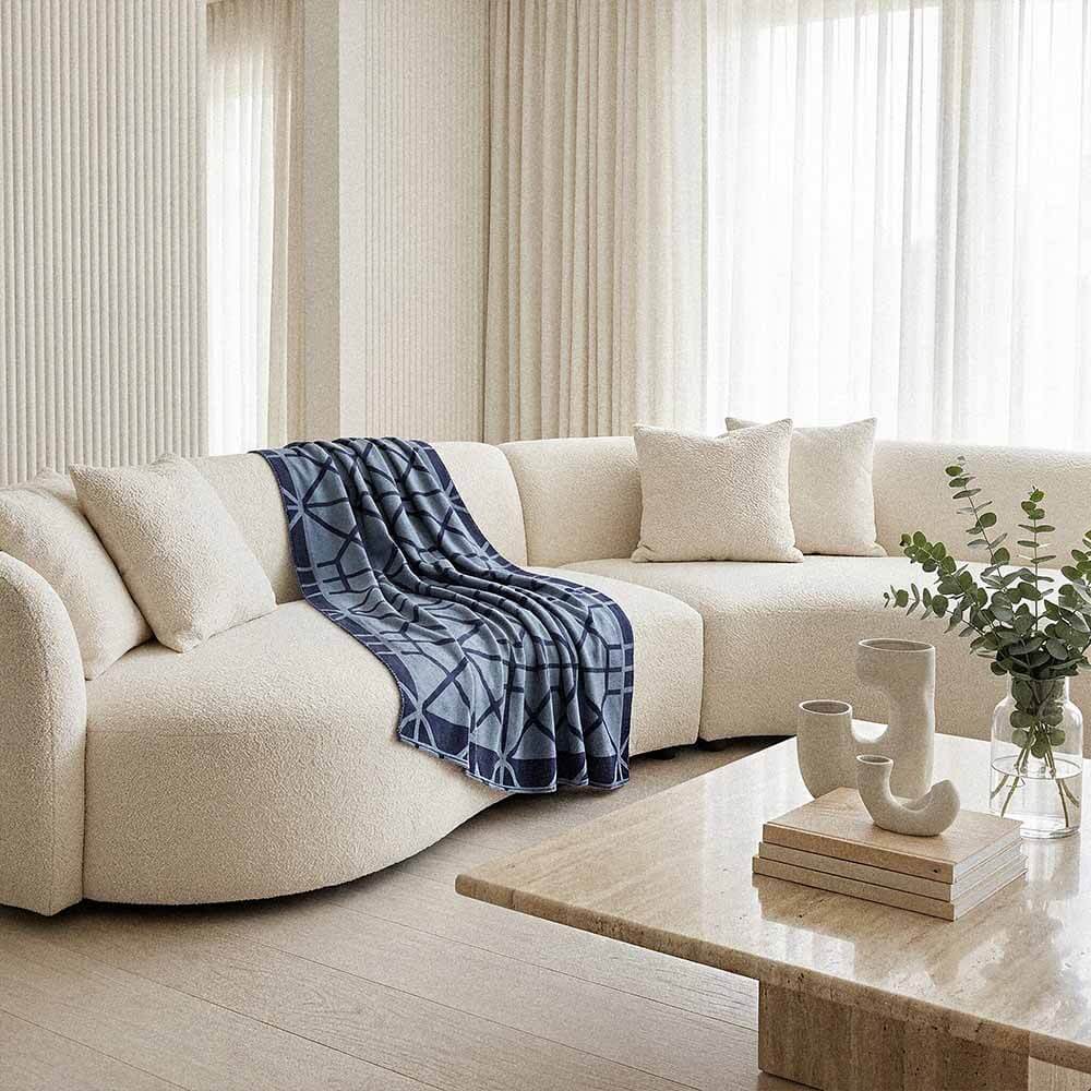 Simone lightweight cotton blanket | Lightweight Geometric Knit 4 navy cotton throw blanket draped on cream upholstered armchair with warm minimalist living room styling