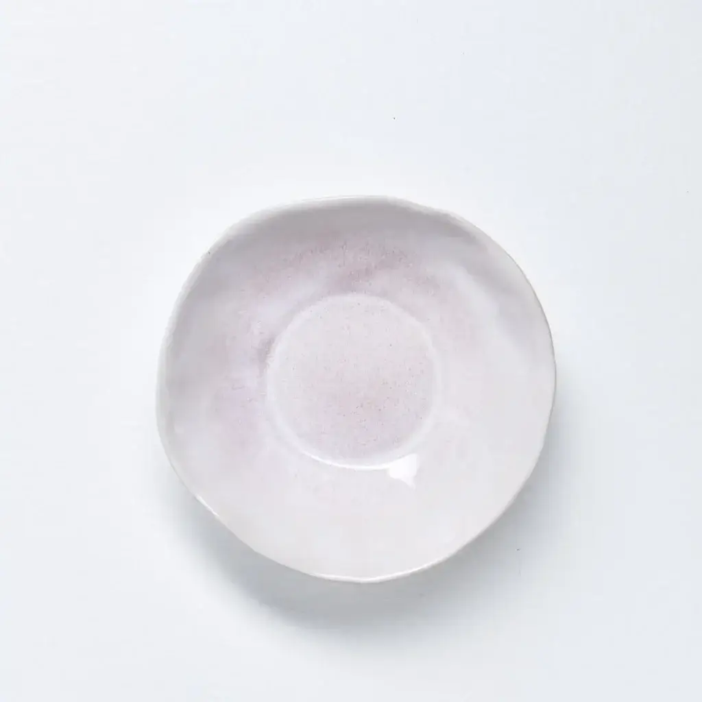Ceramic Dinnerware | The Pros and Cons of Everyday Use in 2024 4 A ceramic soup bowl with a delicate light pink glaze on the inside and a smooth matte white finish on the outside. The bowl has an organic, slightly irregular shape, emphasizing its handmade quality.