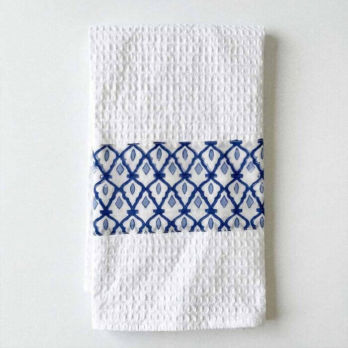 Cotton waffle tea towel in blue and white folded on kitchen counter with handmade kitchenware
