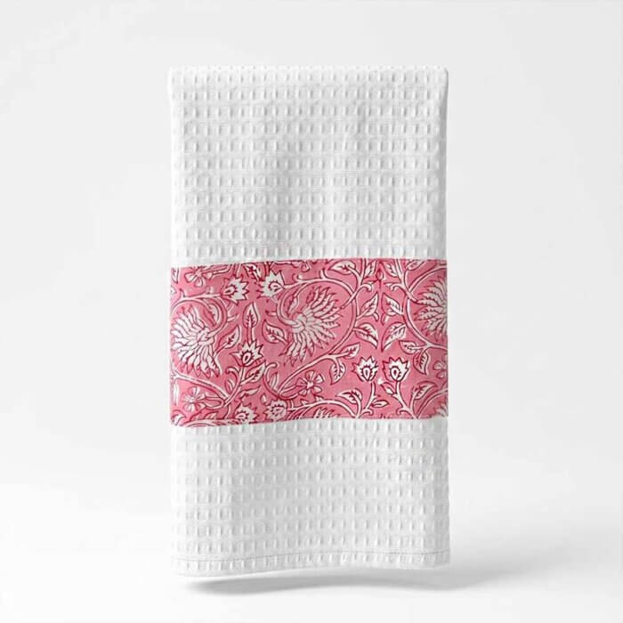 Floral block print tea towel in pink and white waffle cotton with hand-printed botanical motif folded on white surface