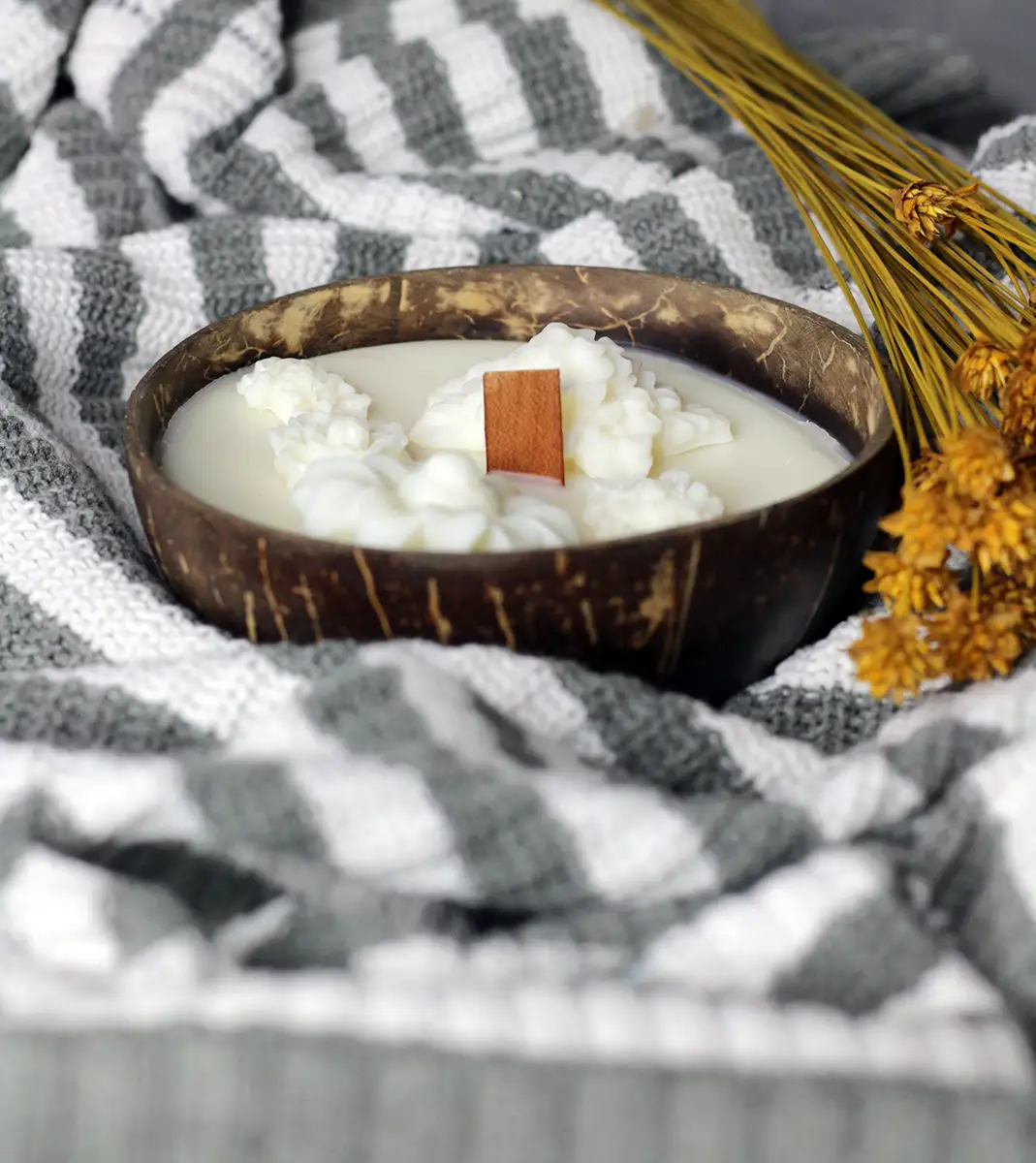 Coconut Shell Candle Dough Bowl 2 Candle Dough Bowl - Soy candle in a natural coconut bowl, featuring a wooden wick and decorative, flower-shaped wax accents, set against a gray and white knitted background. wood wick dough bowl candle