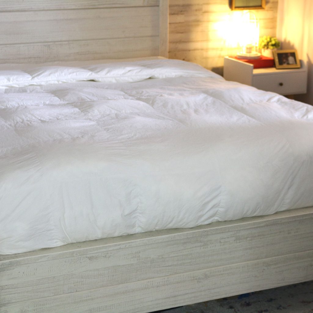 a bed layered with fitted sheet, flat sheet, and duvet