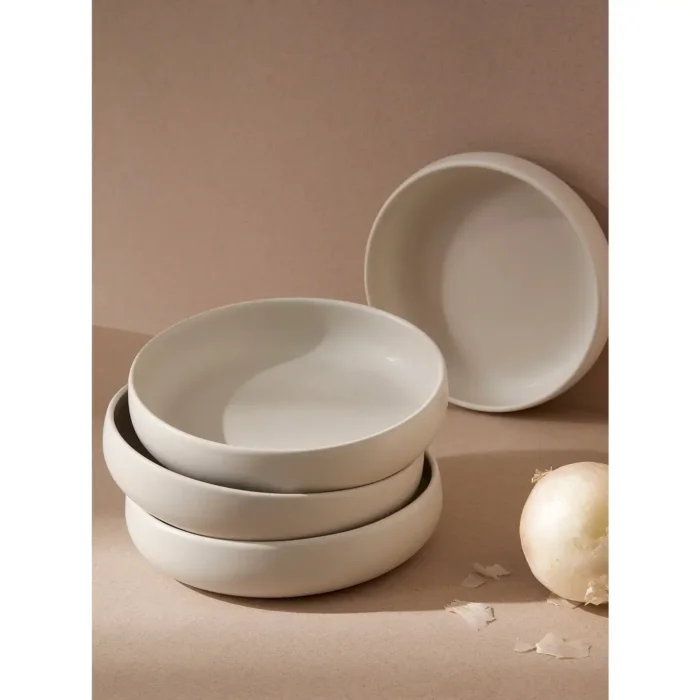 Stack of white GHARYAN Stoneware Pasta Plates, showcasing their smooth finish and handcrafted design against a neutral backdrop.