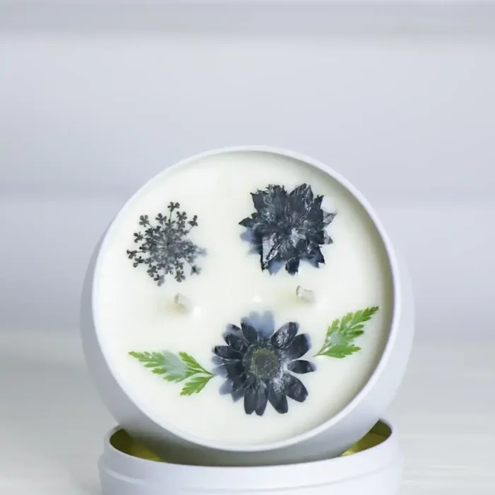 Open small Dried Flowers Tin Candles showing floating dried flowers inside.