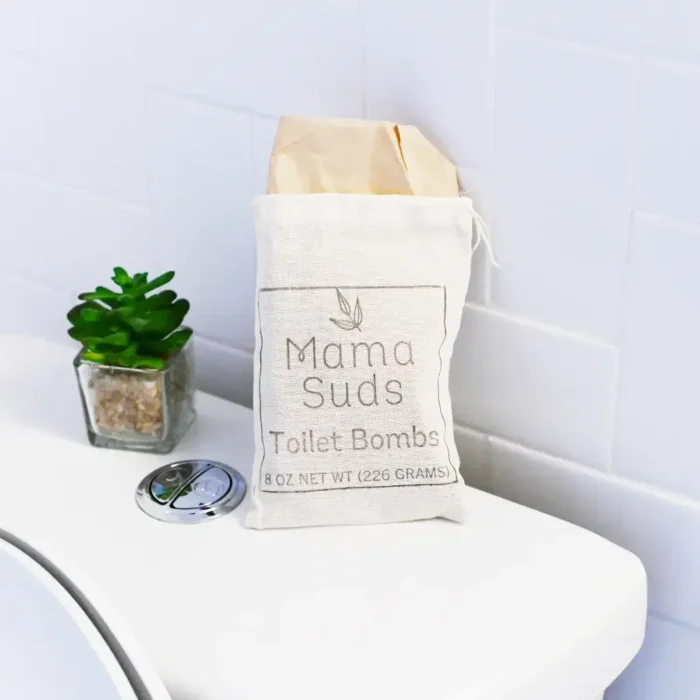 eco friendly Toilet Cleaning Tabs MamaSuds Toilet Bomb Cleaning Tabs in a muslin bag on a toilet tank.