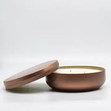 picture of a tin candle with the lid on the side.