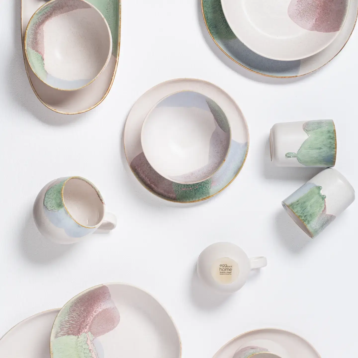 Formal vs. Casual Ceramic Dinnerware: Which to Choose? (2024 Guide) 1 A top-down view of various pieces from the Douro Cup collection by Egg Back Home, showcasing plates, bowls, and cups with a beautiful shiny glaze finish and vivid colors.