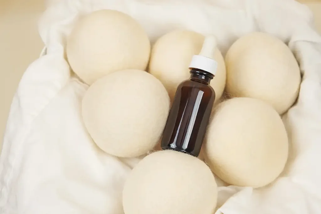 The Benefits of Using Essential Oils in Your Laundry 2 Wool dryer balls with a bottle of essential oil. Do essential oils damage washing machines?