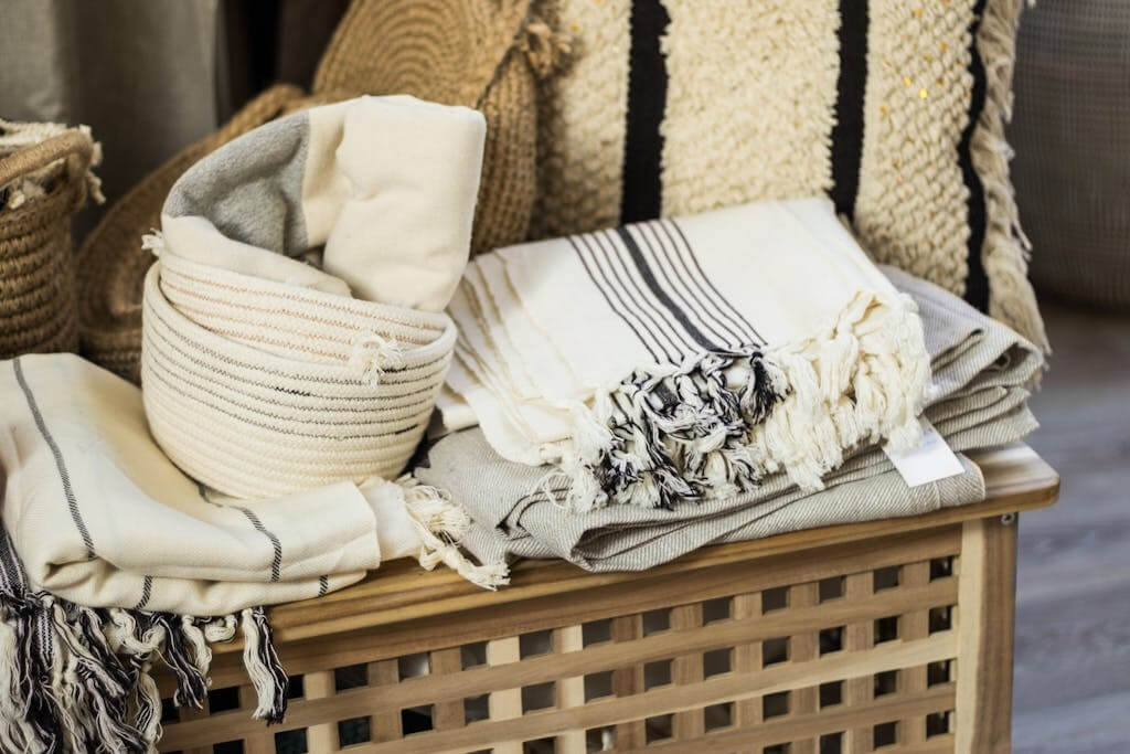 How To Care For Your Organic Cotton Duvet 8 Stacked towels , duvet covers and plaid on wooden box