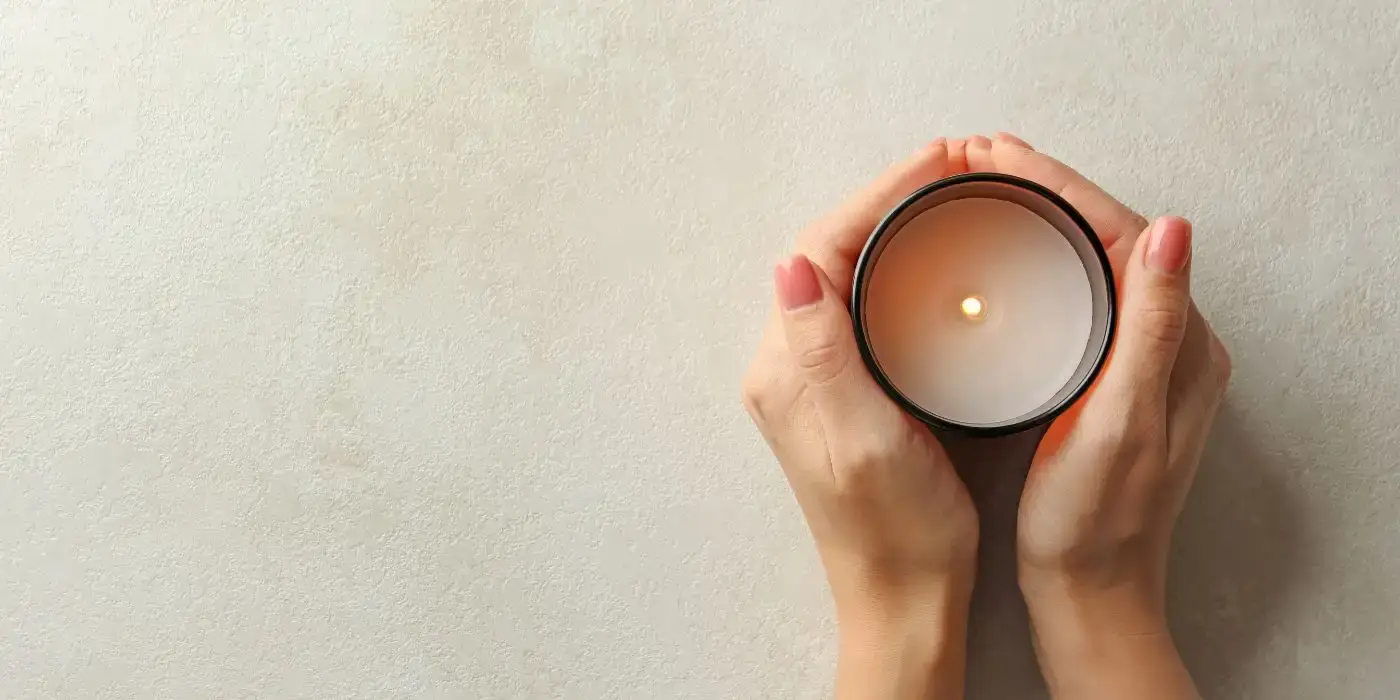 Candle Safety Tips for Your Home: Essential Guide for 2024 1 hands holding a candle on white background. Candle Safety Tips