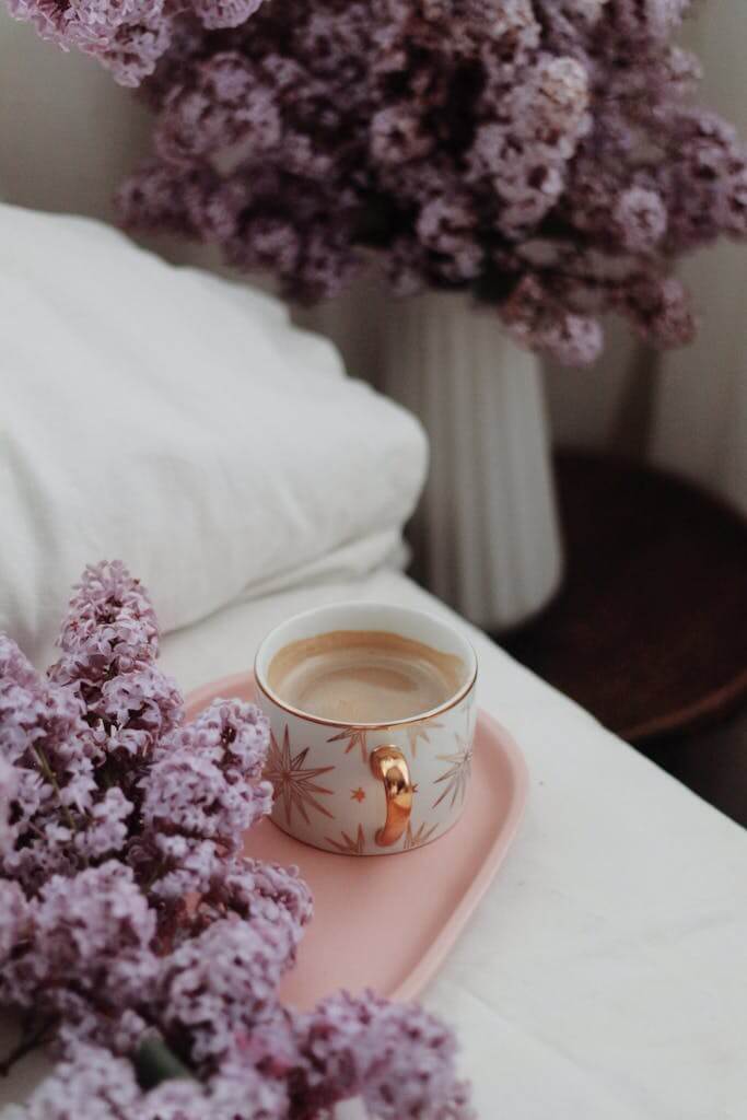Natural Ways to Make Your House Smell Good Without Candles: A Comprehensive Guide 2 From above elegant cup with cappuccino served on tray on comfy bed and decorated with lush lilac bouquet in cozy bedroom