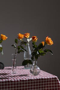Glass vases with orange roses in blossom in table. ROOM COLOR PSYCHOLOGY IN HOME DECOR
