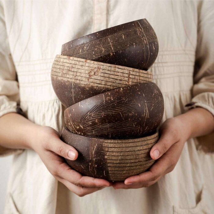 2 hands holding jumbo jumbo coconut bowl