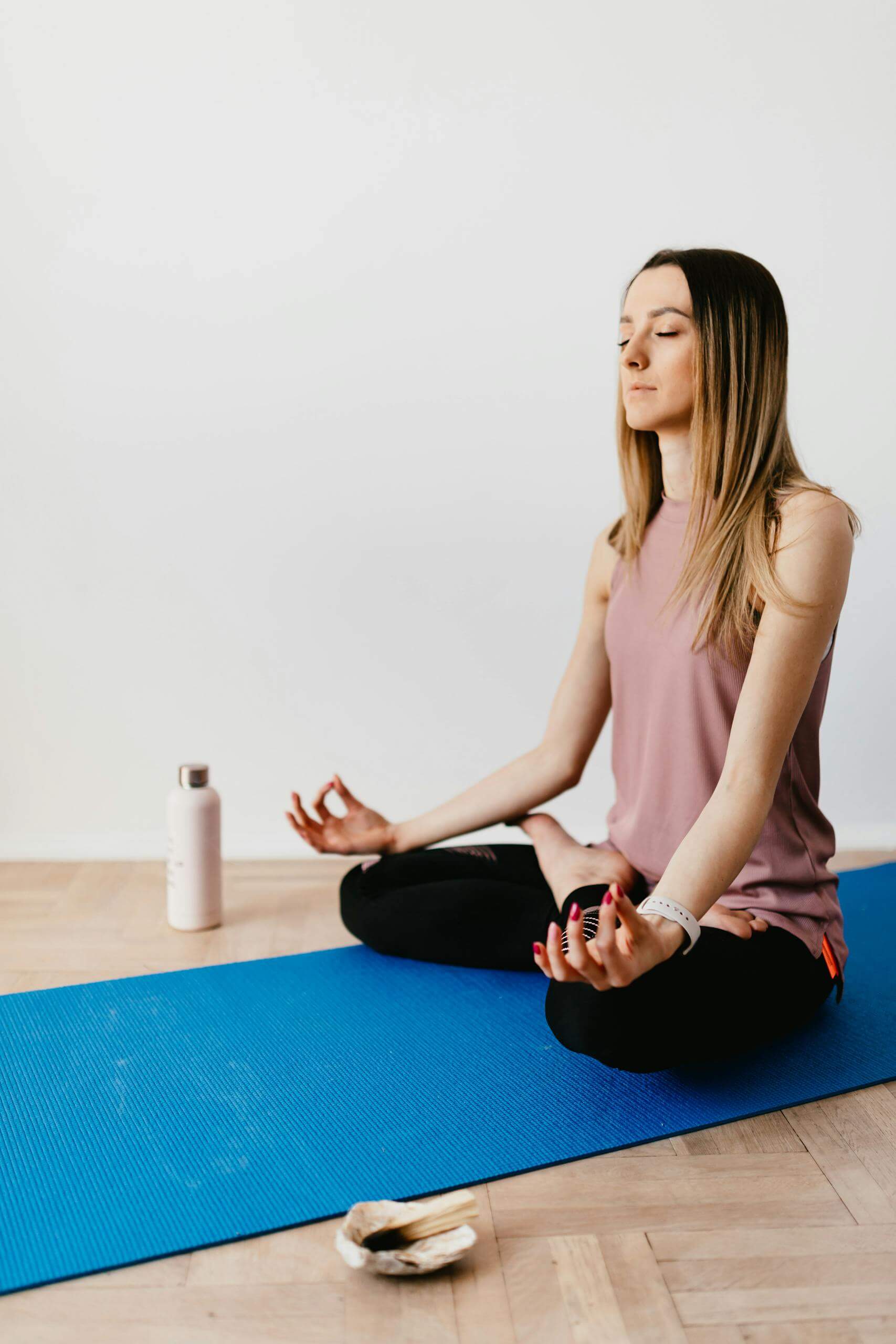 10 Best Meditation Apps for Beginners: Start Your Mindfulness Practice Today 1 Slim female with closed eyes meditating alone in pose of lotus on rubber blue mat. Meditation Apps