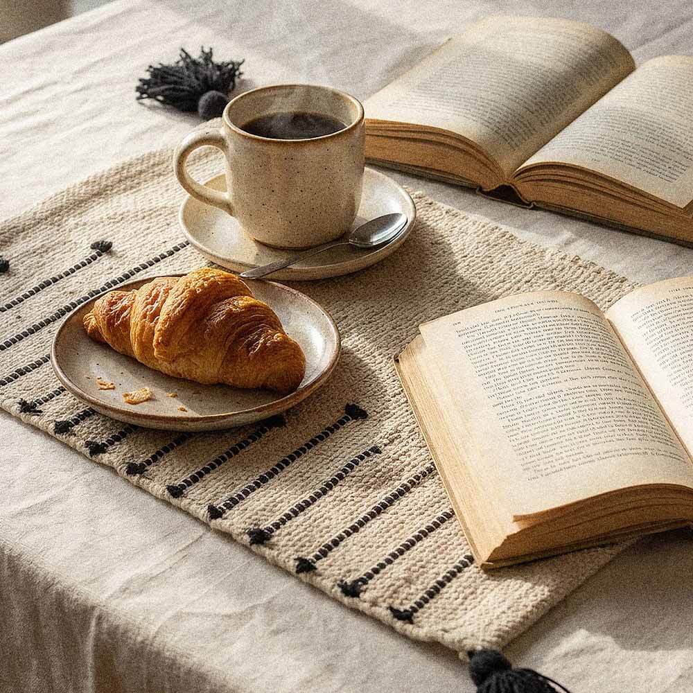 Cotton Placemats for Dining Table | Threadwork in Cream and Black | Set of 2 1 Cotton placemats for dining table in cream with black threadwork pattern and tassels, styled with coffee and book in morning light