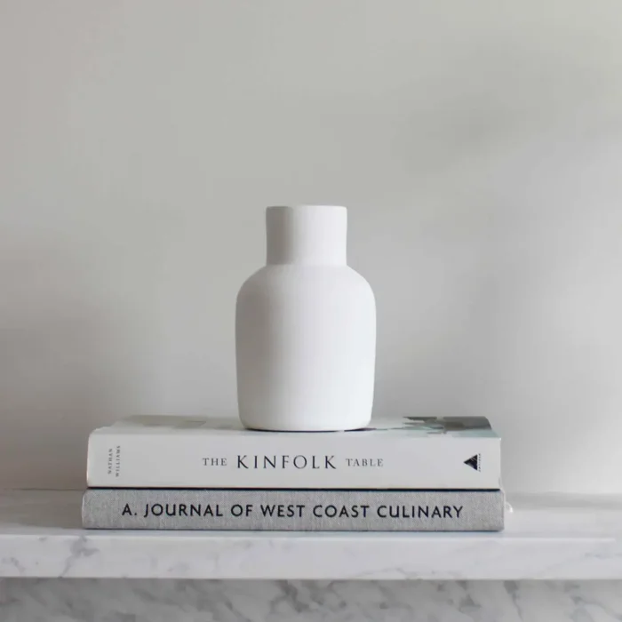 white ceramic vase on a stack of books Handmade White Flower Vase