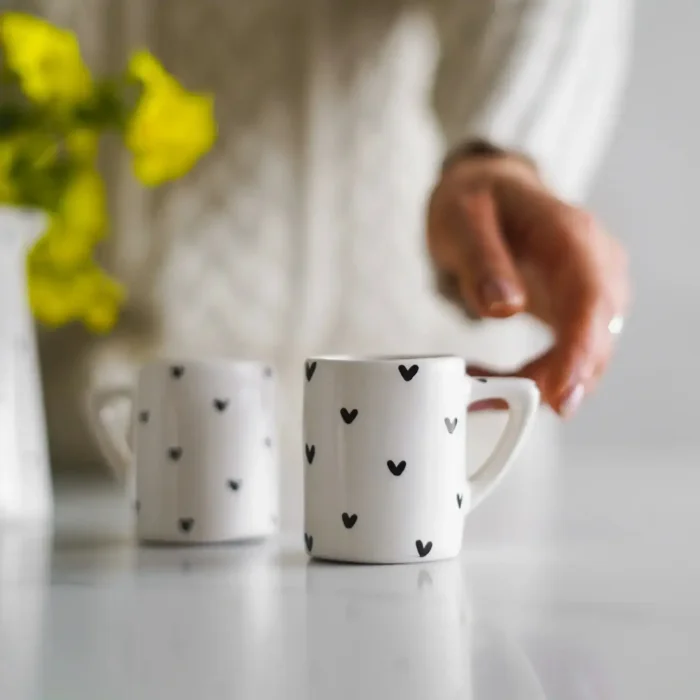 black and white hearts ceramic mugs hand holding black and white handmade ceramic mug set