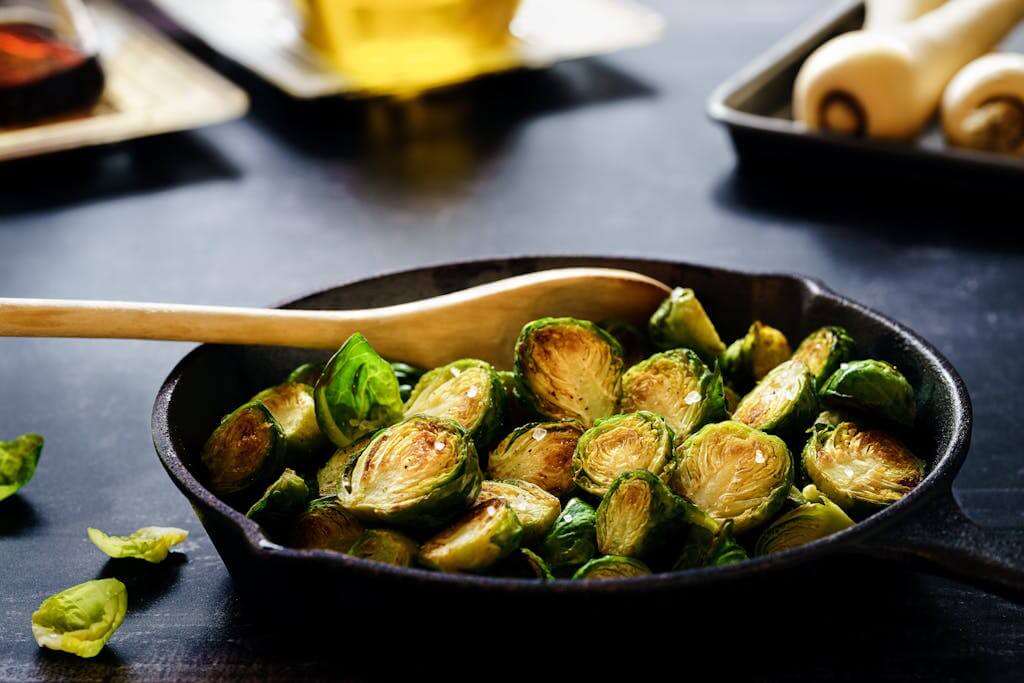 The Healthiest Material for Cookware| Your Guide to the Best Materials for Pots & Pans in 2025 8 Close-up of delicious roasted Brussels sprouts in a cast iron skillet, perfect for a healthy meal.