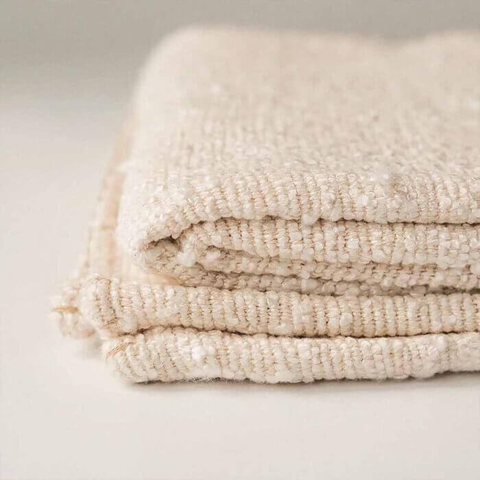 Machine washable cotton boucle throw blanket in rust, folded to show soft texture and woven detail.